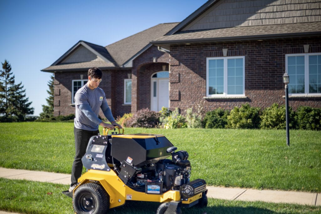 Heartland Grounds team member performing aeration for a residential property